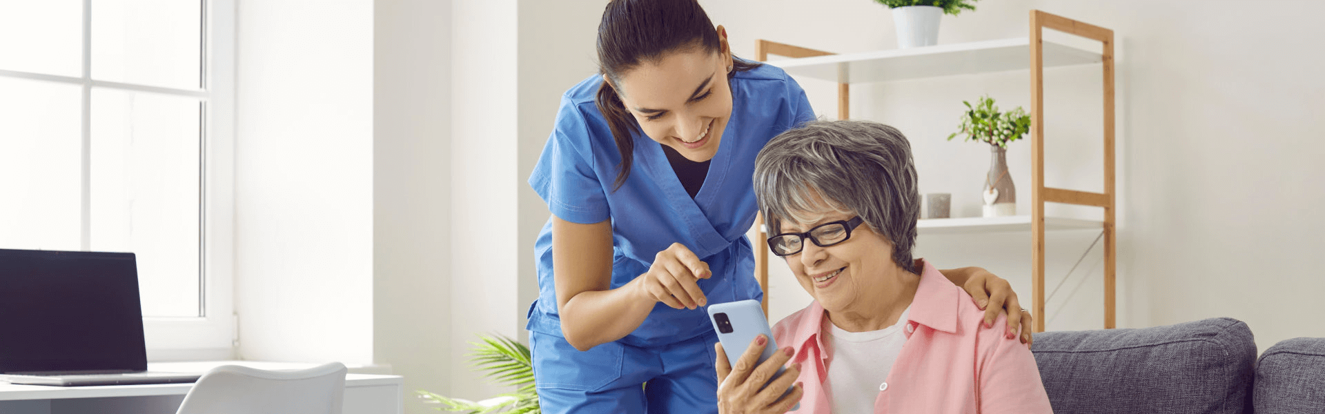 caregiver and elderly woman reading a site in their phone